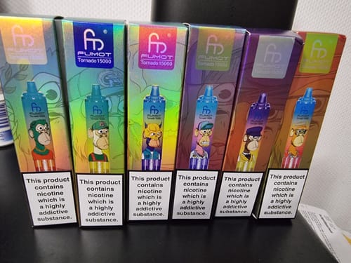 Ein Kunde zeigt die bunten Verpackungen von sechs verschiedenen RANDM TORNADO 15000 Vapes, die nebeneinander aufgereiht sind.