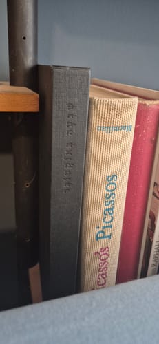 לקוח מציג את שדרת הספר 'שבעה באוקטובר' על מדף ספרים בביתו.