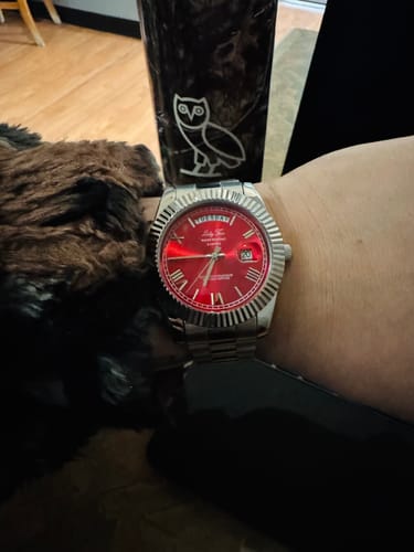 Customer wearing the silver Lucky Fours® Santos watch with a striking red dial on their wrist.