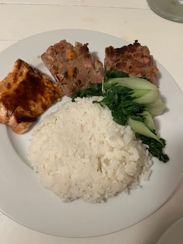 Reviewer's meal featuring taro cake made with Halal Chicken Franks, served with rice and vegetables on a white plate.