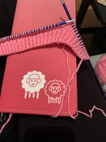 Reviewer knitting with pink yarn on their blue Knit Pro Zing knitting needles.