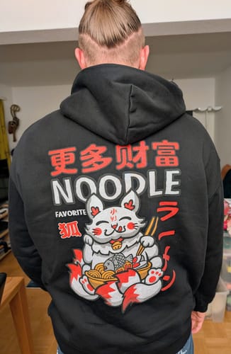 Reviewer seen from behind wearing the black Noodle Hoodie, showing the detailed Japanese-inspired graphic on the back.