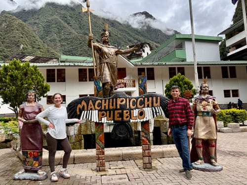 Customer wearing brown Piper Pocket Leggings while posing with a man at Machu Picchu.