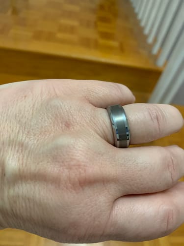 Customer's hand wearing the Alaric ring, showing its satin-brushed finish and polished beveled edges.