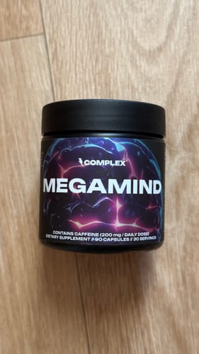 Customer's black tub of Complex MegaMind supplement resting on a light wooden surface.