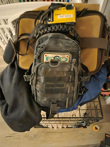 Reviewer's dirty black TAC BAG shown with a camera attached to the handle and an FD patch on the front.