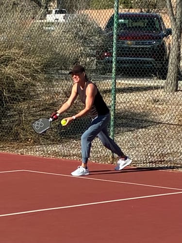 Reviewer playing pickleball on a court wearing the white MUUV Flow Wide Toe Box Pickleball Shoes.