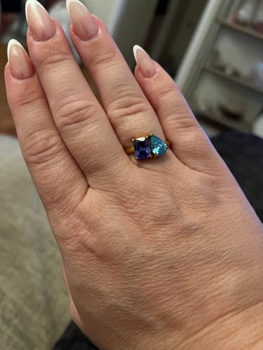 Customer showing their Toi Et Moi Birthstone Ring on their hand. The gold ring has a dark blue and a light blue stone.