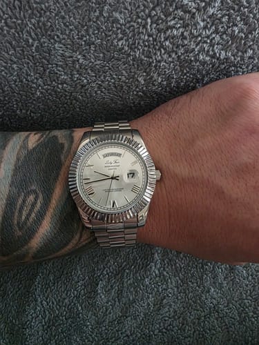 Customer wearing the silver Lucky Fours® Santos watch on their tattooed wrist.