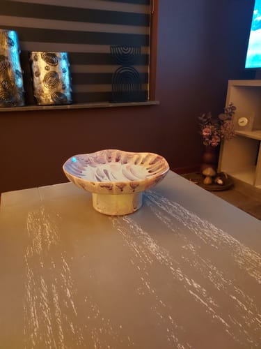 Recensent toont de golvende Ondra serveerschaal op een tafel in een woonkamer.