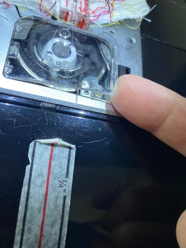 Reviewer shows the clear cover plate perfectly fitted on their sewing machine.
