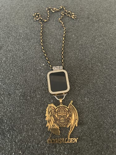 Customer's custom gold logo pendant with a winged skull, shown on their own chain with another digital-style pendant.