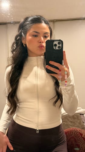 Reviewer taking a mirror selfie in the fitted cream Curve Jacket.