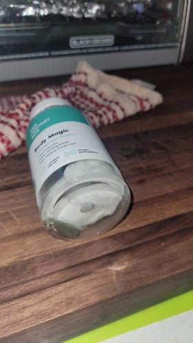 Customer's nearly empty bottle of Body Magic Chlorophyll Pills lying sideways on a wooden counter.
