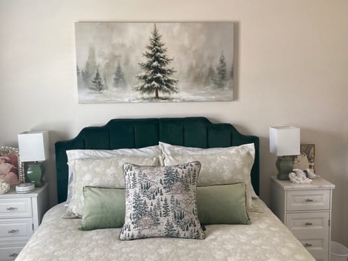 Customer's Snowy Christmas Tree Christmas Wall Art hanging in a bedroom above a bed with a dark green headboard.