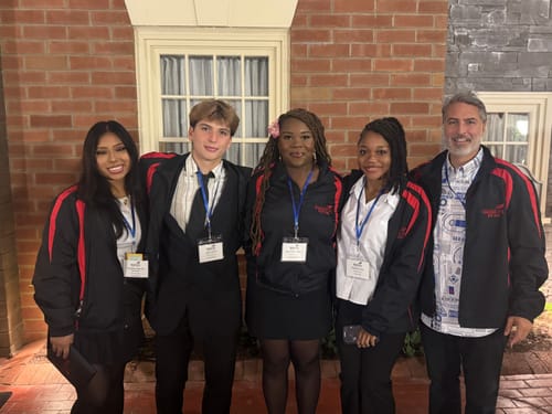 Reviewer wearing the Star Wars™ 'R2 Deconstructed' shirt with four people at a SkillsUSA conference.
