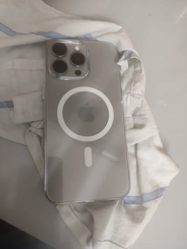 Reviewer's Anti Yellow Magsafe Clear Case shown on the back of a white titanium iPhone 15 Pro Max, lying on a cloth.