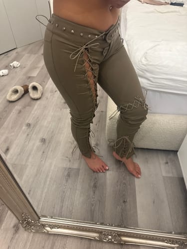 Reviewer in a mirror selfie showing the fit of the tan Vice Pant with lace-up sides and a low-rise waist.