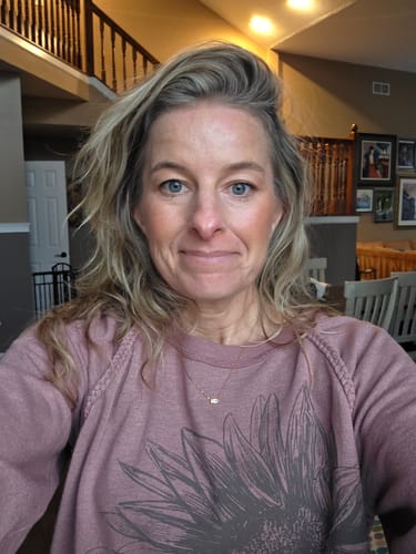 A reviewer wears the simple Baguette Birthstone Necklace, which sits lightly on her collarbone.