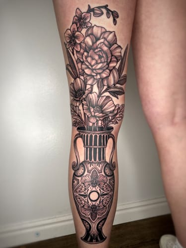 Reviewer showing a large floral vase tattoo on their leg, done in one session using Painless Tattoo Numbing Cream.