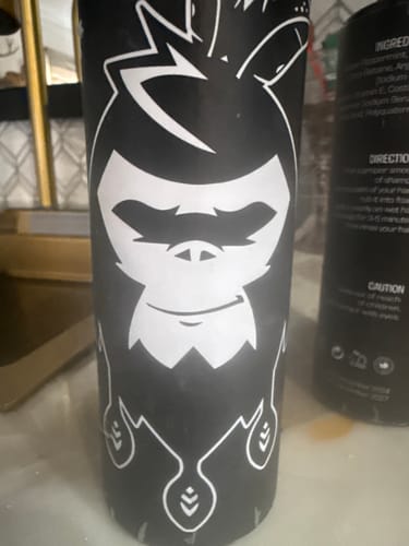 Close-up of a customer's black bottle from the Hair Care Kit, featuring the brand's white chimp logo.