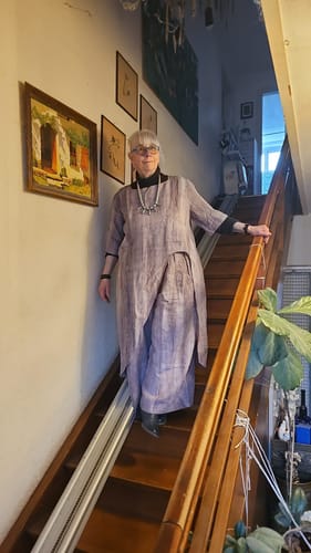 Reviewer on a staircase wearing the loose vintage-style linen suit, showing the fit of the tunic top and wide-leg pants.