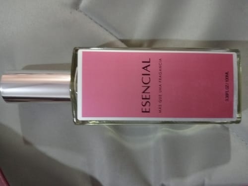 El cliente muestra el frasco del perfume M541 acostado de lado, revelando su etiqueta rosa y tapa plateada.