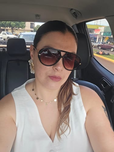 Cliente usando os Óculos Veneza com armação preta e lentes degradê dentro de um carro.