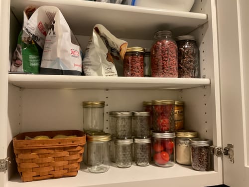 Customer's organized pantry with various foods stored in mason jars, sealed for freshness using the Mason Genie.