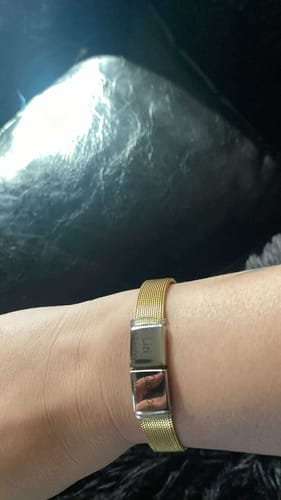 Customer's wrist wearing the gold mesh Lux bracelet, showing the central pendant.