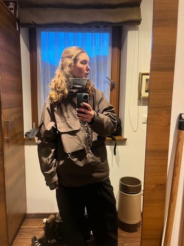 Reviewer taking a mirror selfie showing the fit of the baggy black Snow Pants.