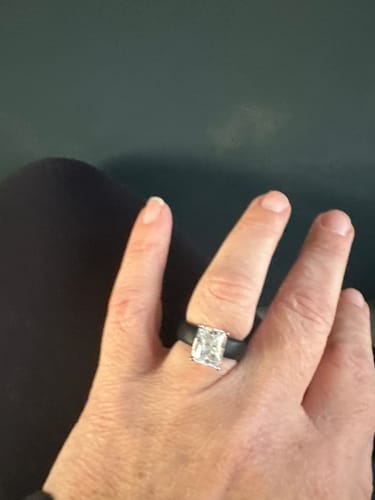 Reviewer's hand wearing the beautiful GlowStone silicone ring, showing the large emerald-cut stone and thick black band.