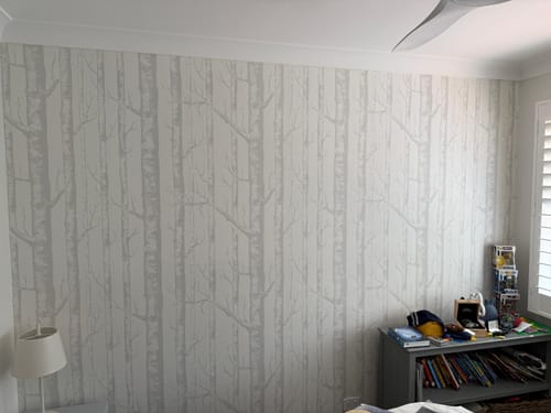 Reviewer's bedroom with a feature wall of the Birch Trees in Grey Wallpaper, showing the full pattern.