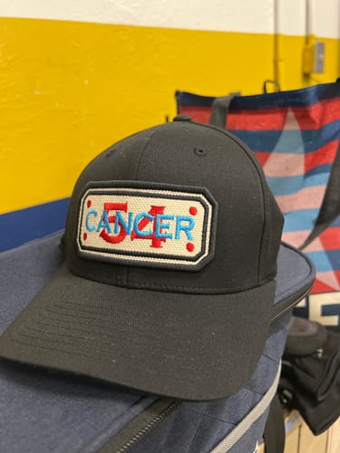 Reviewer's custom black FLEX-FIT HOSE HAT with a patch reading 'CANCER' with the number '54' in the center.