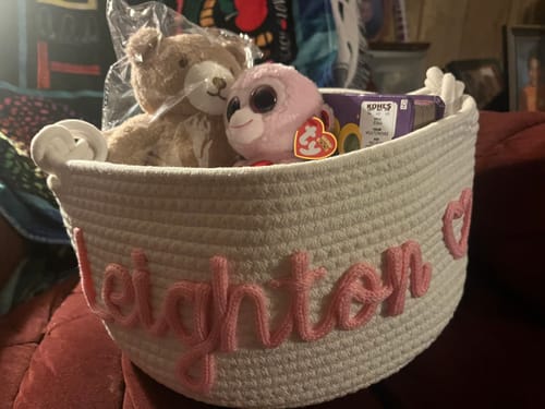 Customer's animal plushie toys, including a teddy bear, inside a personalized woven basket.