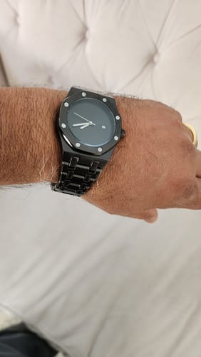 Customer showing the black Lucky Fours® Auron watch with a metal band on their wrist.