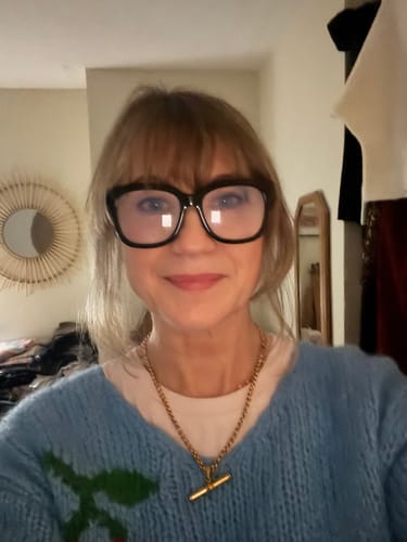 A reviewer wearing the chunky gold XL T-Bar Necklace over a light blue sweater and white t-shirt.