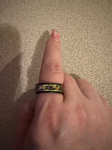 Customer's hand wearing the black Titanfall ring, showing the detailed meteorite and gold flake inlay.
