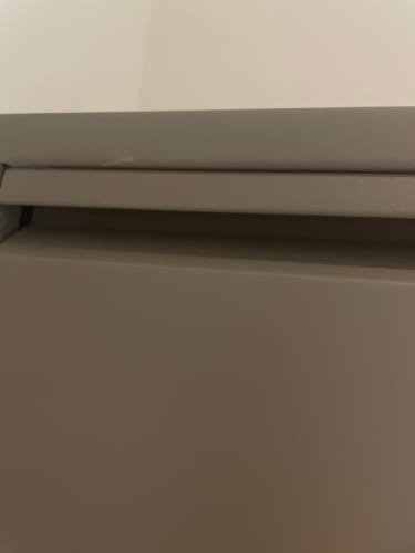 Close-up van een recensent van een beschadiging op de taupe Schoenenkast Caruso.