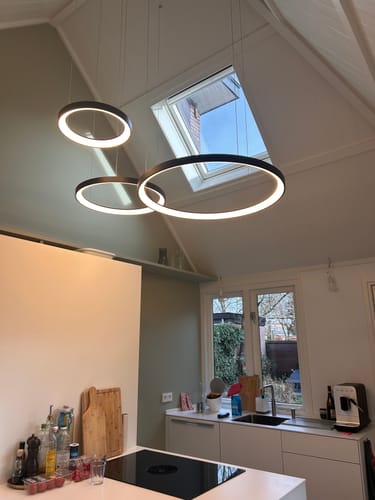 Klant's zwarte VIDAL hanglamp opgehangen in de hoge nok van een keuken met schuin plafond.