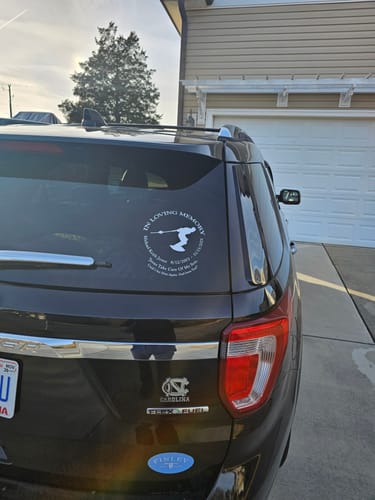 Customer's white Wakeboarding In Loving Memory decal applied to the rear window of a black SUV.