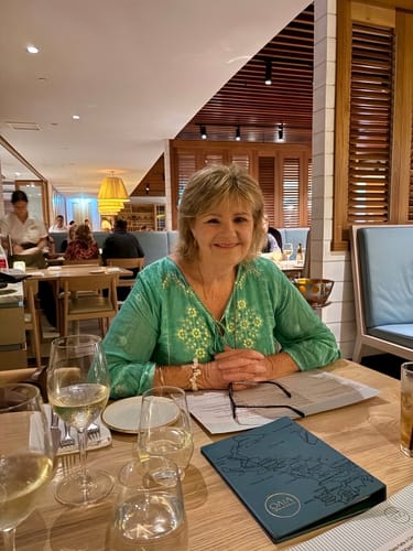 Reviewer for Organic Moringa Capsules smiling while seated at a table in a restaurant.