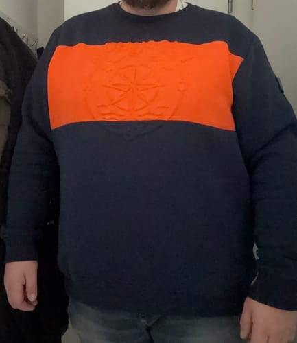 Rezensent trägt das Mooinzen Sweatshirt in Dunkelblau mit einem breiten orangen Bruststreifen.