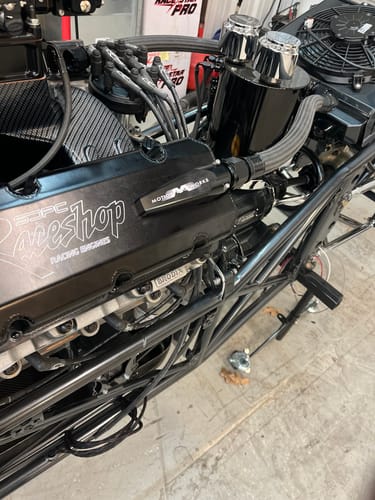 Customer's black quick release breather fittings installed on the valve cover of a race engine.