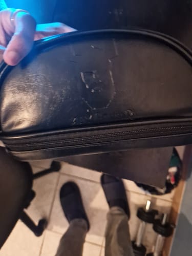 Client tenant la trousse noire Max-Barber® dont le logo semble endommagé.