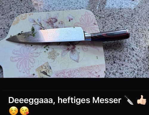 Kunde zeigt das Asiatische Chef Messer mit gehackten Kräutern auf einem verzierten Schneidebrett.