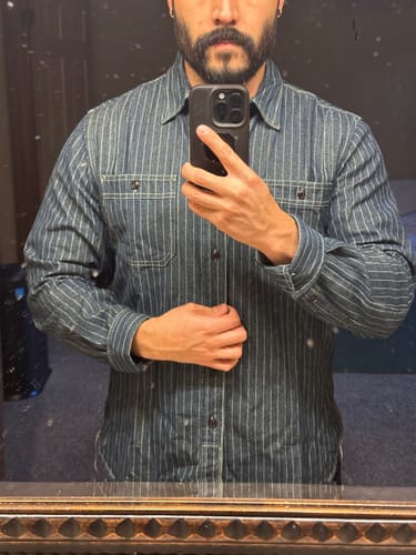 Reviewer wearing the striped Wabash Vent Hole Work Shirt, showing the fit across the chest and shoulders in a mirror photo.
