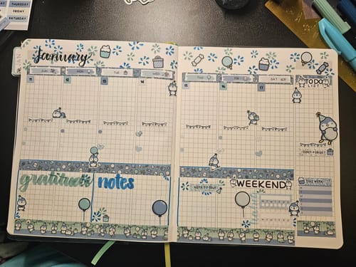 Customer's weekly planner spread for January using the Ultimate Subscription's blue and green penguin-themed stickers.