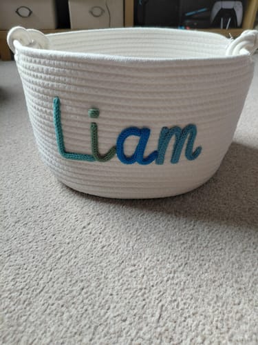 Reviewer's personalized white woven basket with the name 'Liam' in blue and green lettering.