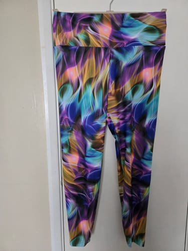 Customer's handmade leggings using the colorful Ethereal Flow jersey fabric, hanging against a white door.